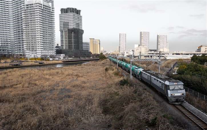 横浜みなとみらいを行く石油を運ぶ貨物列車、左奥から右手前に向かって走っている。